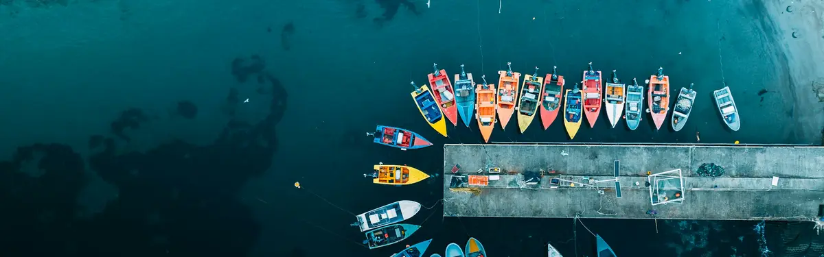 Colorful boats docked at a pier on a dark day