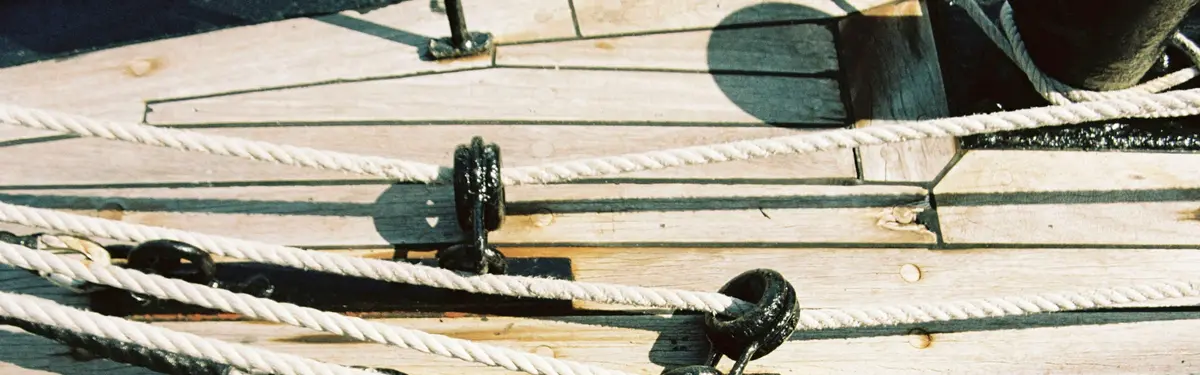 Thick ropes run through pulleys on a wooden deck.